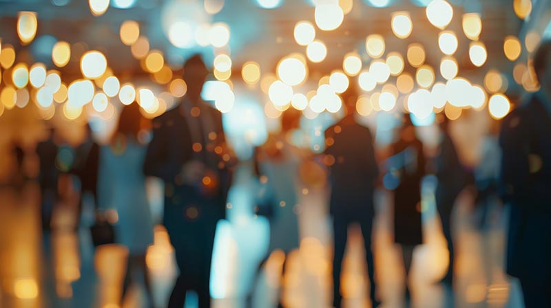 Motion-blurred candid of unidentified business professionals socializing at a corporate gathering